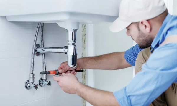 Loodgieter handen vaststelling van waterkraan — Stockfoto