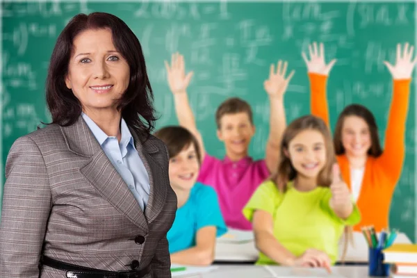 Жінка-вчителька з дітьми в класі — стокове фото