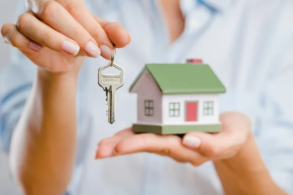 Huis in menselijke hand — Stockfoto