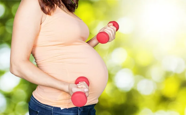 Zwangere vrouw uitoefenen met halters — Stockfoto