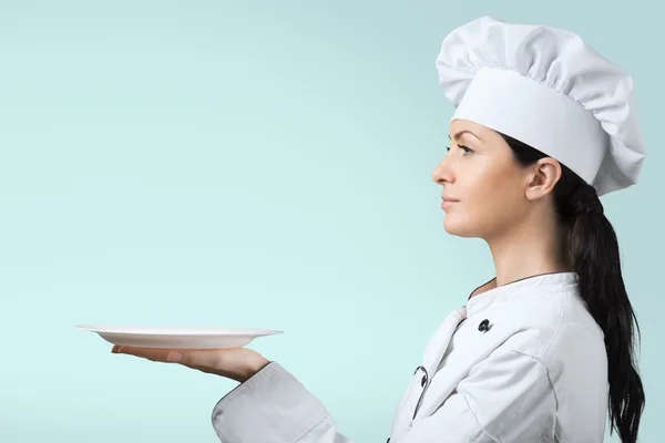 Молодая женщина шеф-повар с тарелкой — стоковое фото