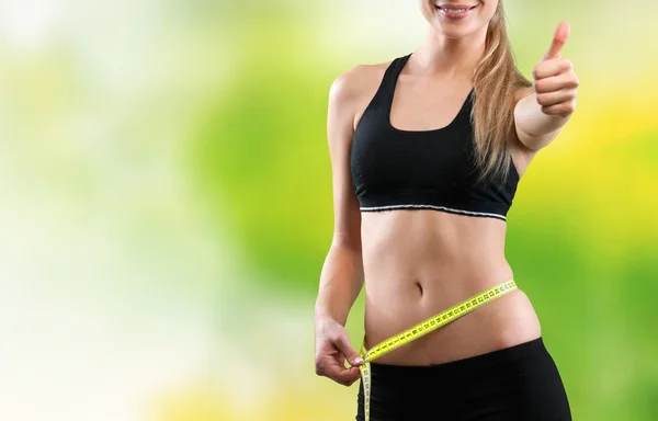 Young woman measuring her thin waist — Stock Photo, Image