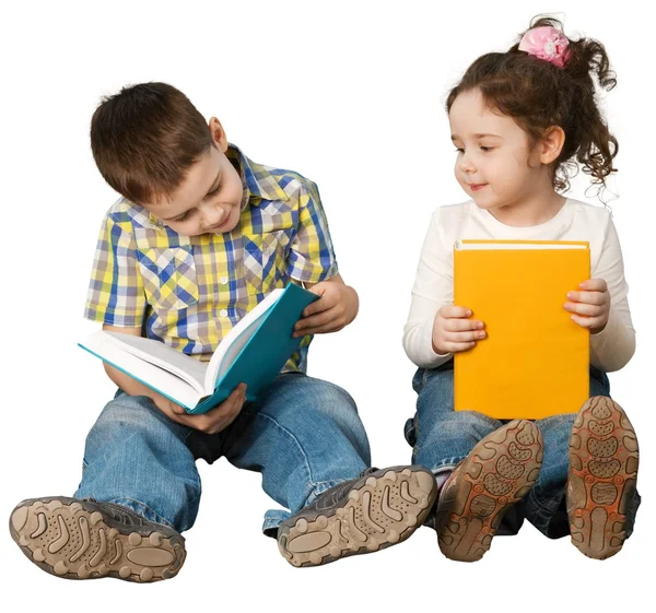 Dos niños sentados en el suelo y leyendo — Foto de Stock