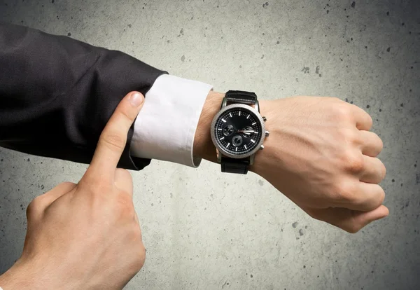 Empresário apontando para relógio de mão — Fotografia de Stock
