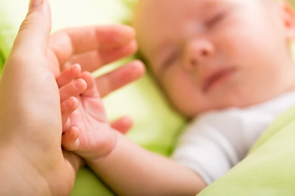 Main le bébé endormi dans la main de la mère — Photo