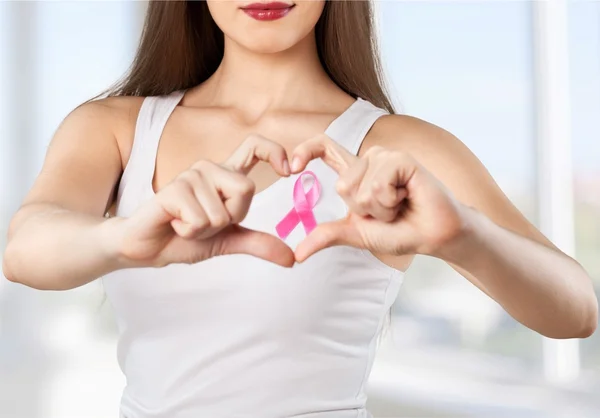 Peito da mulher com crachá rosa — Fotografia de Stock