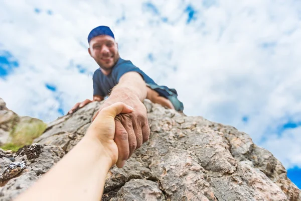 Abenteurer helfen sich gegenseitig beim Klettern — Stockfoto