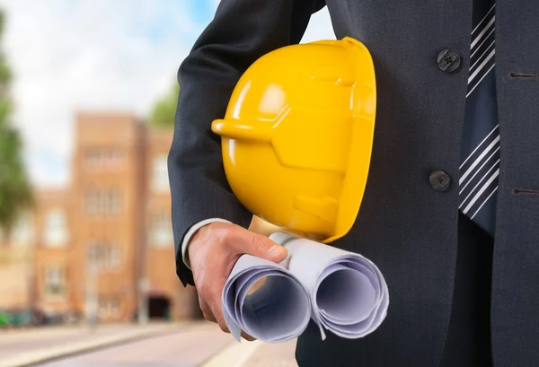 Trabalhador da construção segurando em planta — Fotografia de Stock