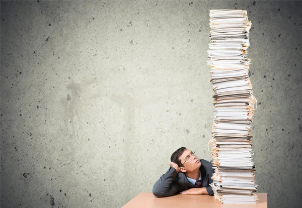 Jeune homme d'affaires avec pile de papiers — Photo