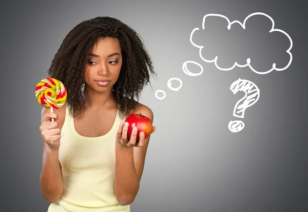 Femme au choix entre bonbons et pomme — Photo