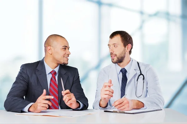 Médico sonriendo con paciente masculino — Foto de Stock