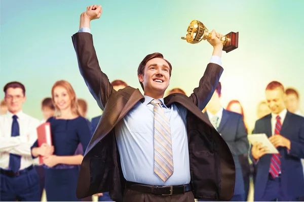 happy businessman with golden cup celebrating