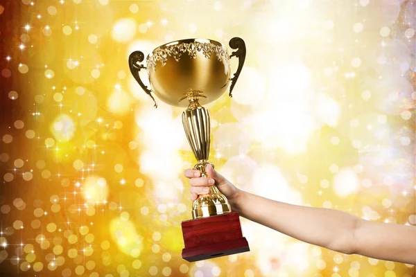 Mão segurando troféu dourado — Fotografia de Stock