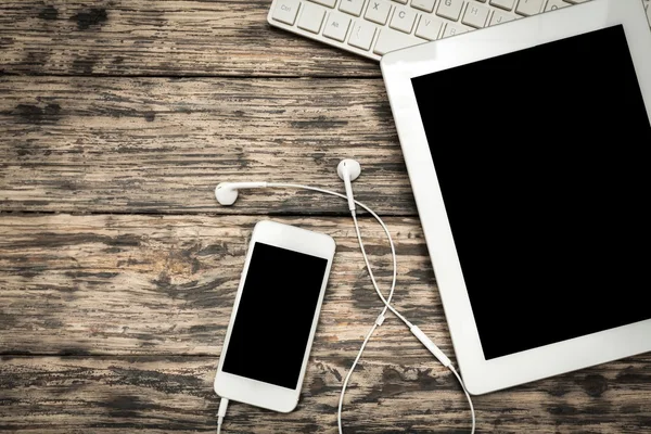 Smartphone con pantalla en blanco y mesa pc — Foto de Stock