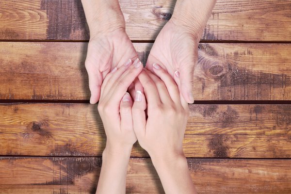 Hands of  old man and a young woman