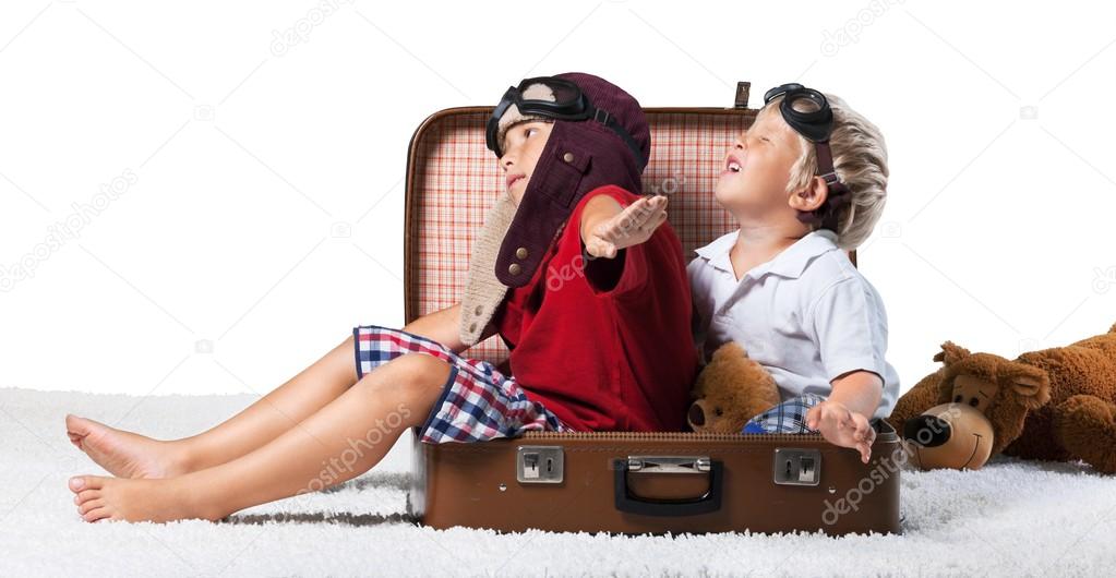 kids sitting at suitcase and fooling around