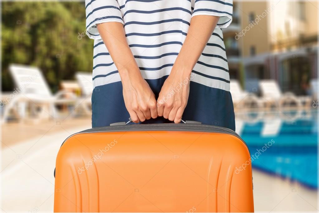 Woman hands holding orange suitcase