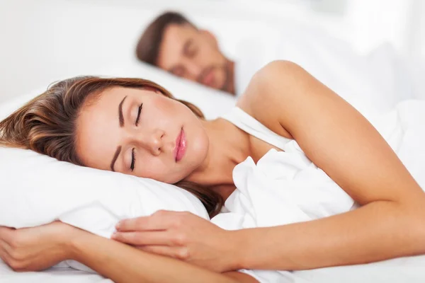 Hermosa pareja joven durmiendo en la cama — Foto de Stock