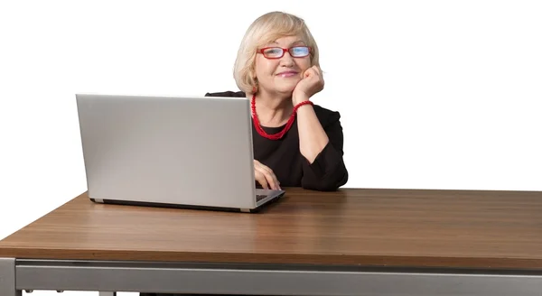 Frau mit grauen Haaren sitzt neben Laptop — Stockfoto