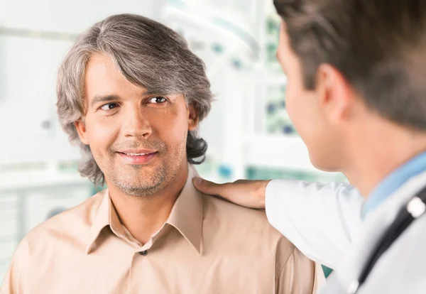 Paciente masculino sonriente con médico —  Fotos de Stock