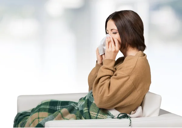 woman sneezing in a tissue