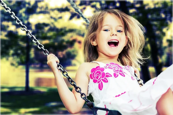 Маленькая девочка веселится на качелях — стоковое фото
