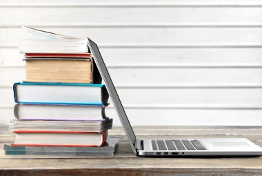 Dizüstü bilgisayar ile kitap yığını