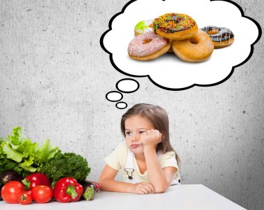 girl choicing  between vegetables and  donuts clipart