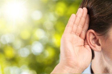 İşadamı kulak yakınındaki elini tutar 