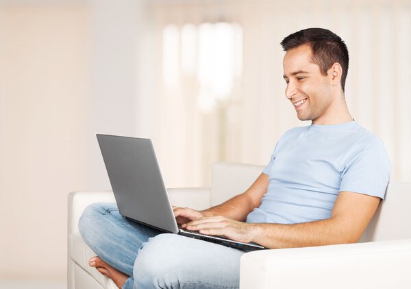 man relaxing on the sofa with a laptop