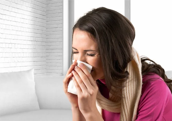 Woman sneezing in a tissue — Stock Photo, Image