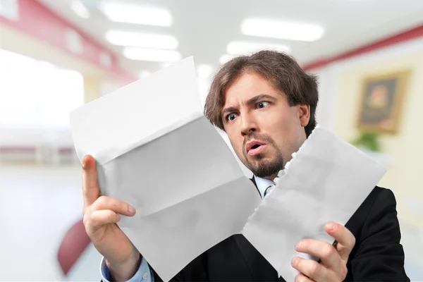 Стрессовый бизнесмен с бумагами — стоковое фото
