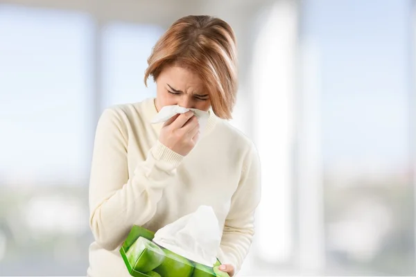 woman holding handkerchieif blowing nose