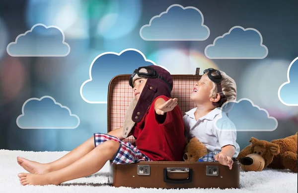 Kids sitting at suitcase and fooling around — Stock Photo, Image
