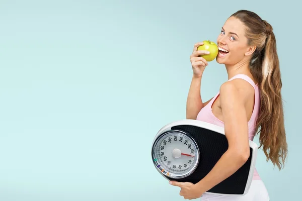 Kobieta z jabłkiem i wagi — Zdjęcie stockowe