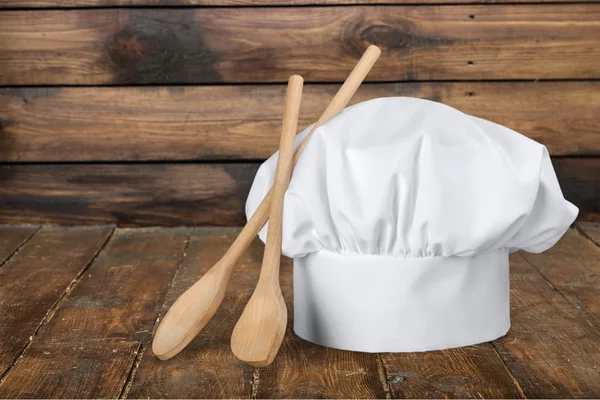 Casquette de cuisinier blanche et cuillères en bois — Photo