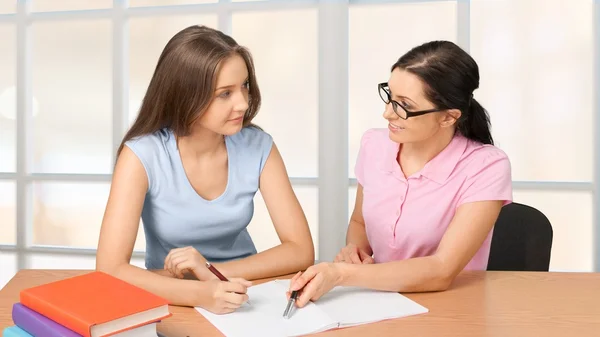 Mère aidant fille heureuse avec des devoirs — Photo