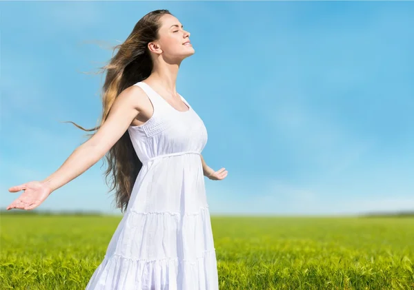 Vrouw op veld onder zonsondergang licht — Stockfoto