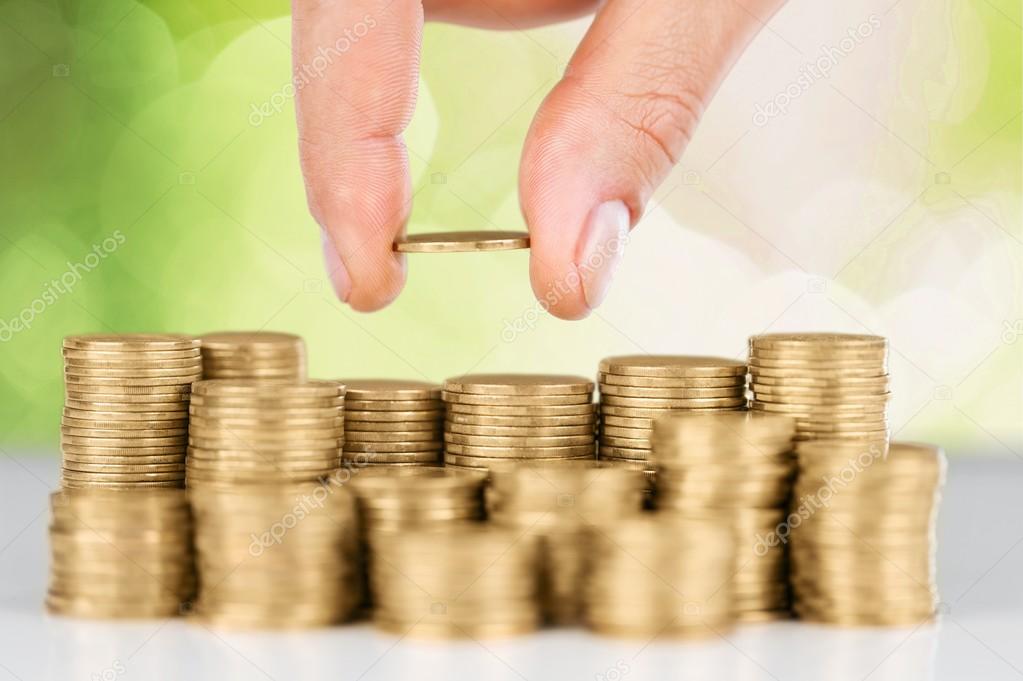 Hand putting coin on coins