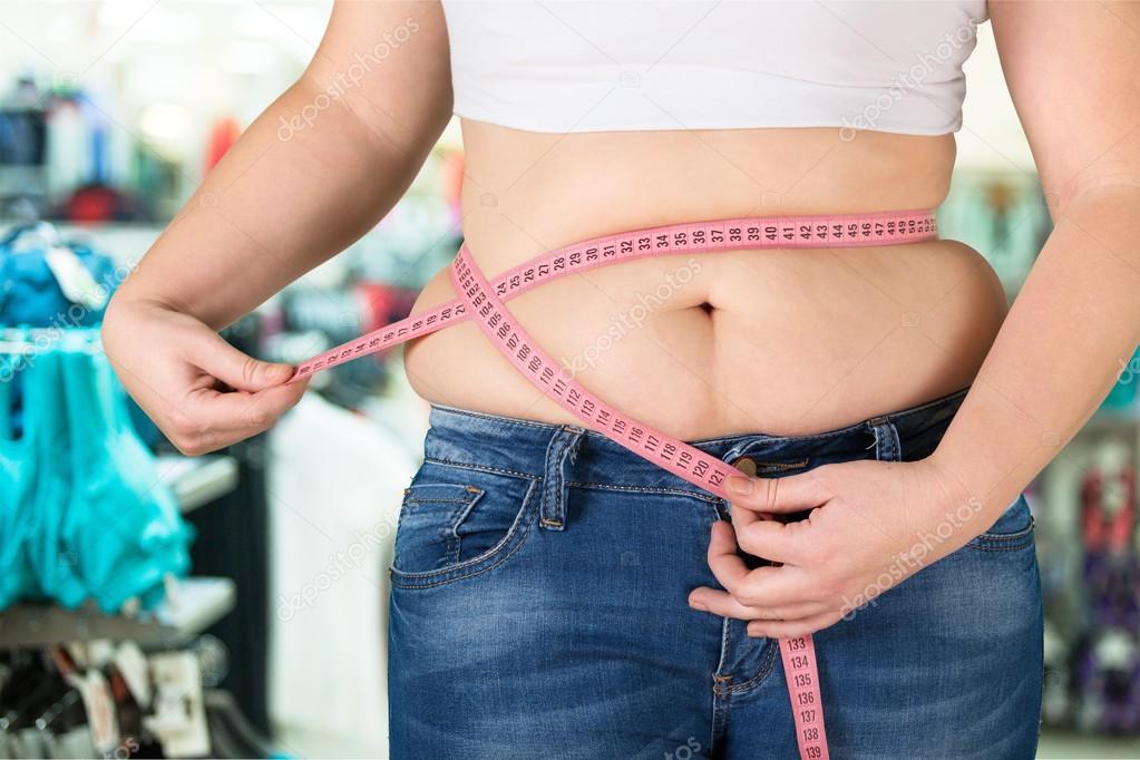 fat woman measuring her stomach