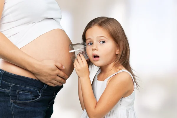 Mulher grávida bonita com sua filha — Fotografia de Stock