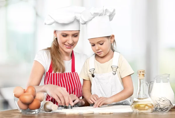 Meisje en haar moeder samen bakken — Stockfoto