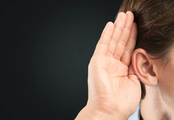 Empresario sostiene su mano cerca de su oreja — Foto de Stock