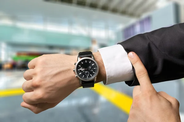 Businessman pointing at hand watch