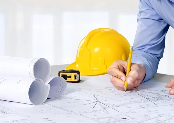 Architect working on construction blueprint — Stock Photo, Image