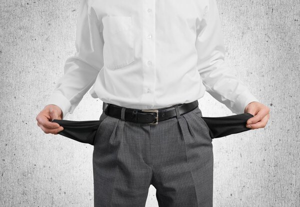 Бизнесмен показывает свои пустые карманы
