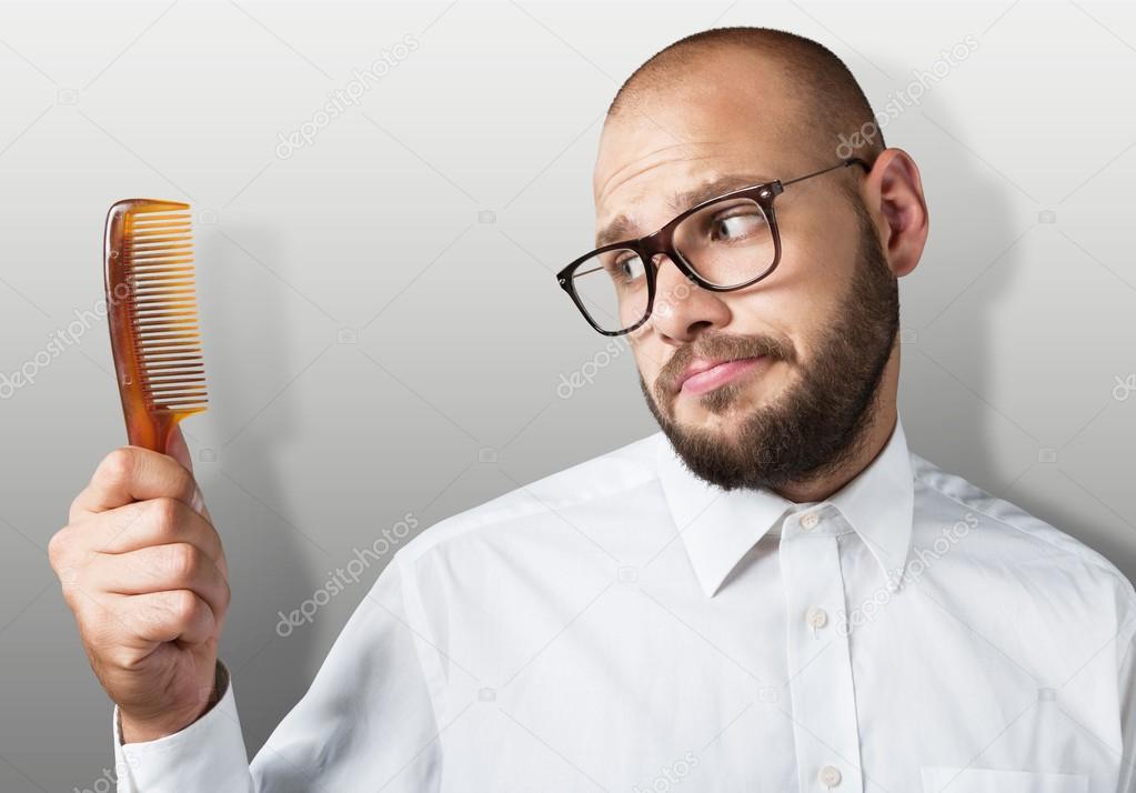 bald  man hand holding comb 
