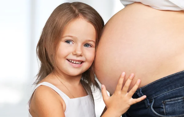 Mulher grávida bonita com sua filha — Fotografia de Stock