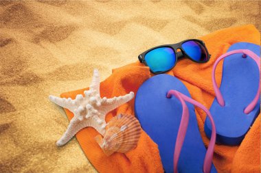 Parmak arası terlik, güneş gözlüğü ve havlu 