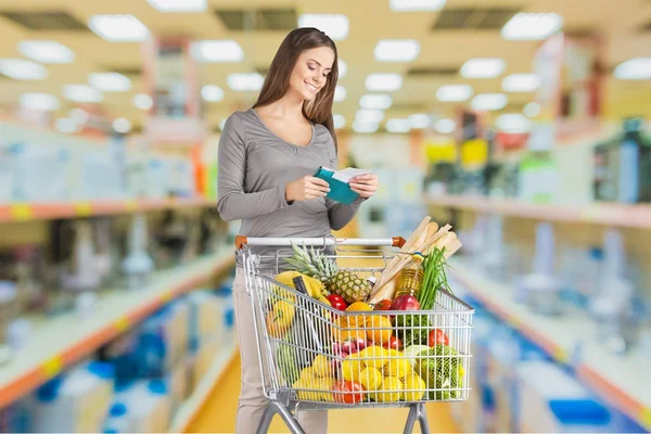 Vrouw met kar winkelen — Stockfoto